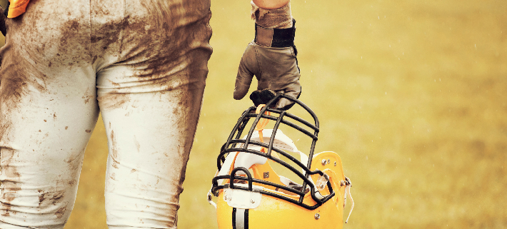 Close-up of american football player holding a helmet